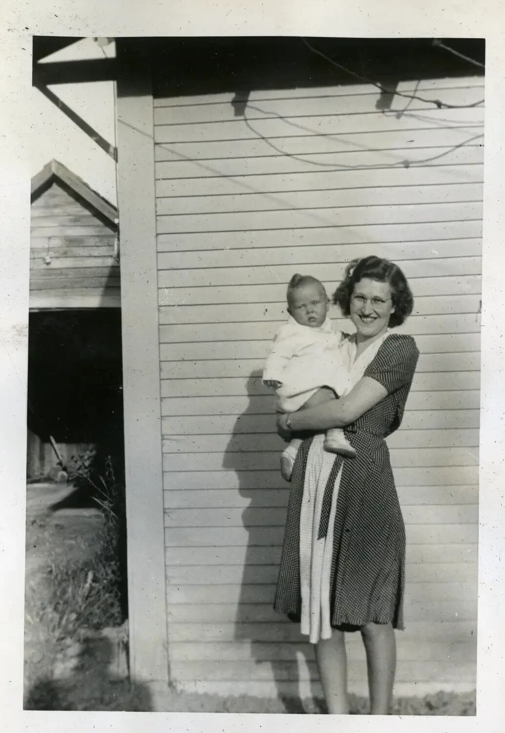 Woman Holding Infant Beside Wood-Frame House, Home Front Snapshot (USS Maryland Album, 1930s-1940s)