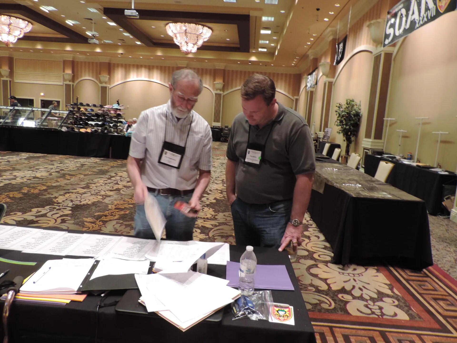 Two Attendees Reviewing Printed Rosters and Reference Lists at a Records Table, SOAR XXXVII, Las Vegas, 2013