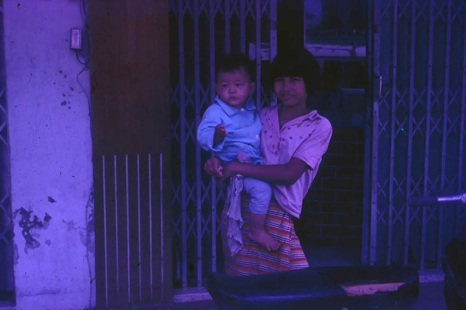 Vietnamese Woman and Child at Shopfront Gate - 1965, 3rd Tactical Fighter Wing Collection