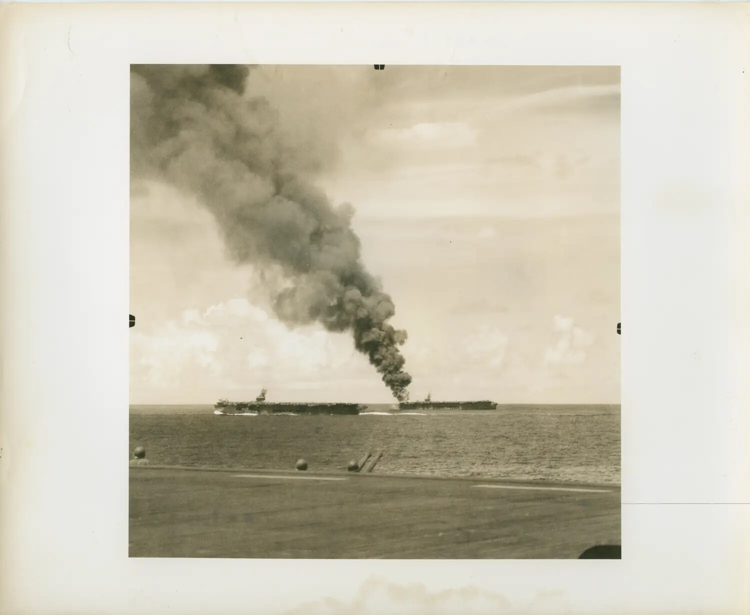 Escort Carrier Afire at Sea, Photographed from a Sister Ship's Flight Deck, WWII Pacific Theater
