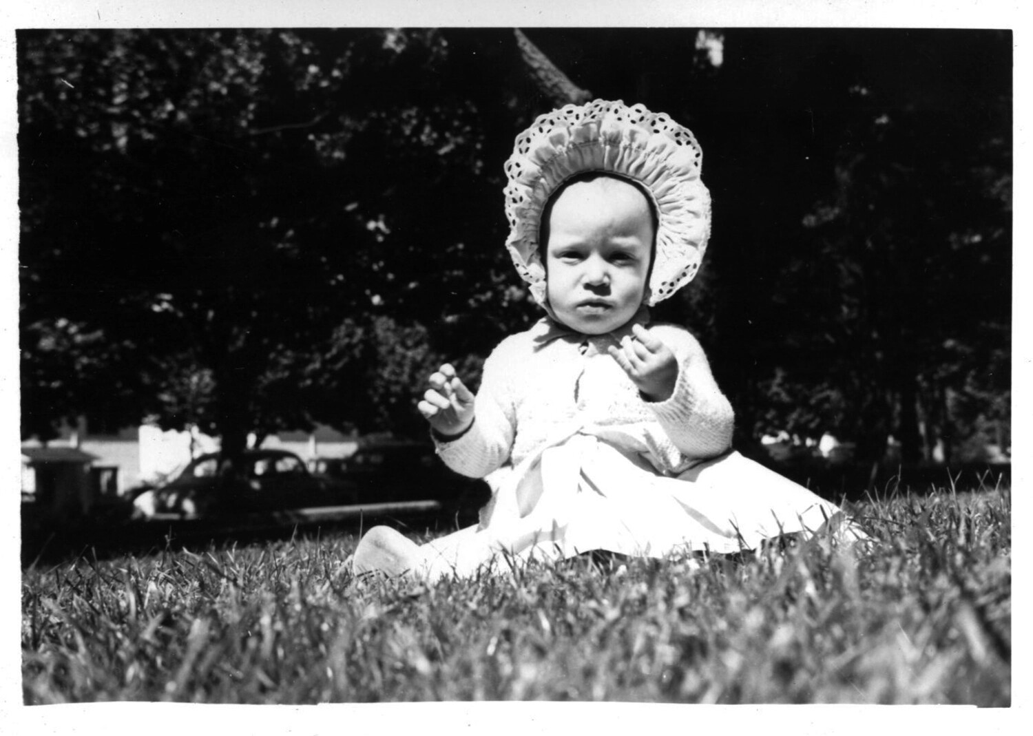 Child in Lace Bonnet Seated on Lawn, Home Front, Korean War Era