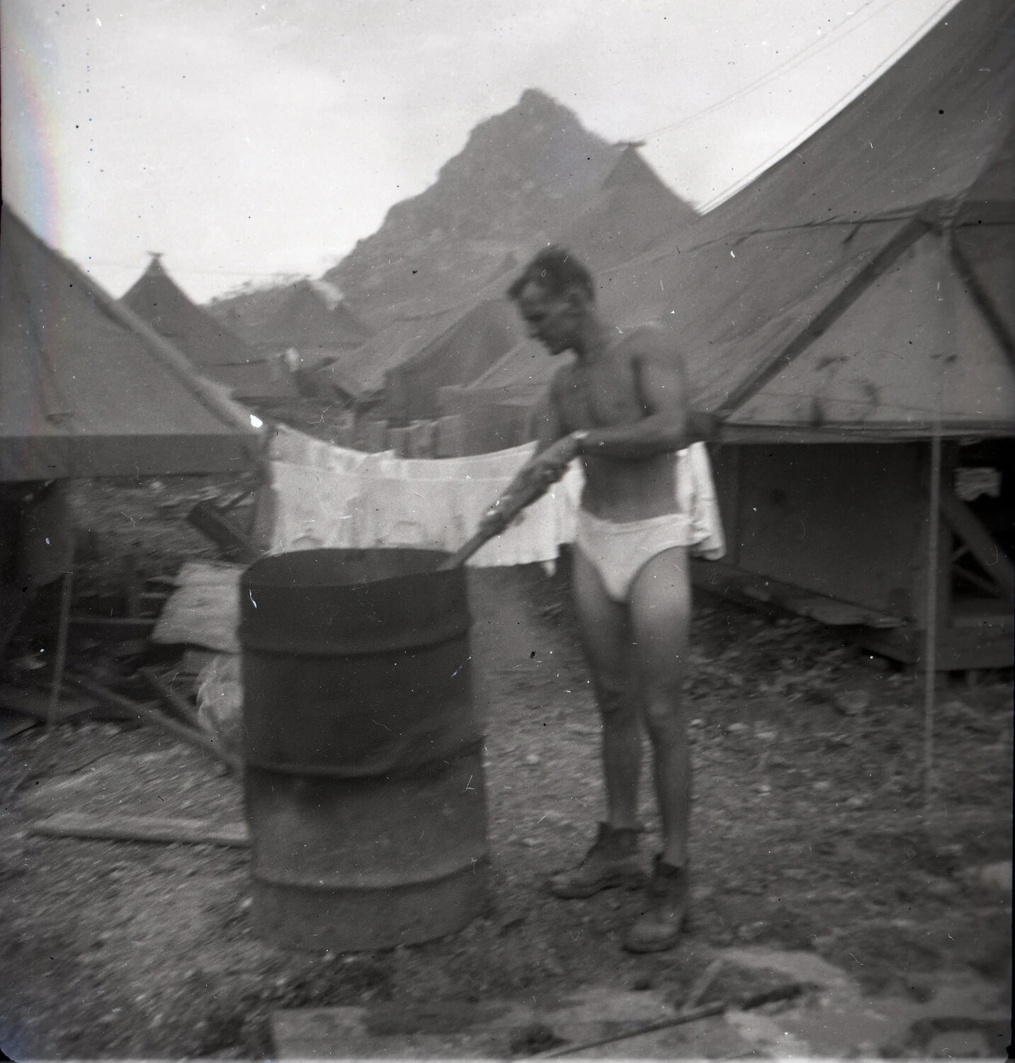 Serviceman Doing Laundry in a Repurposed Oil Drum, 345th Bomb Group Encampment, Ie Shima, WWII