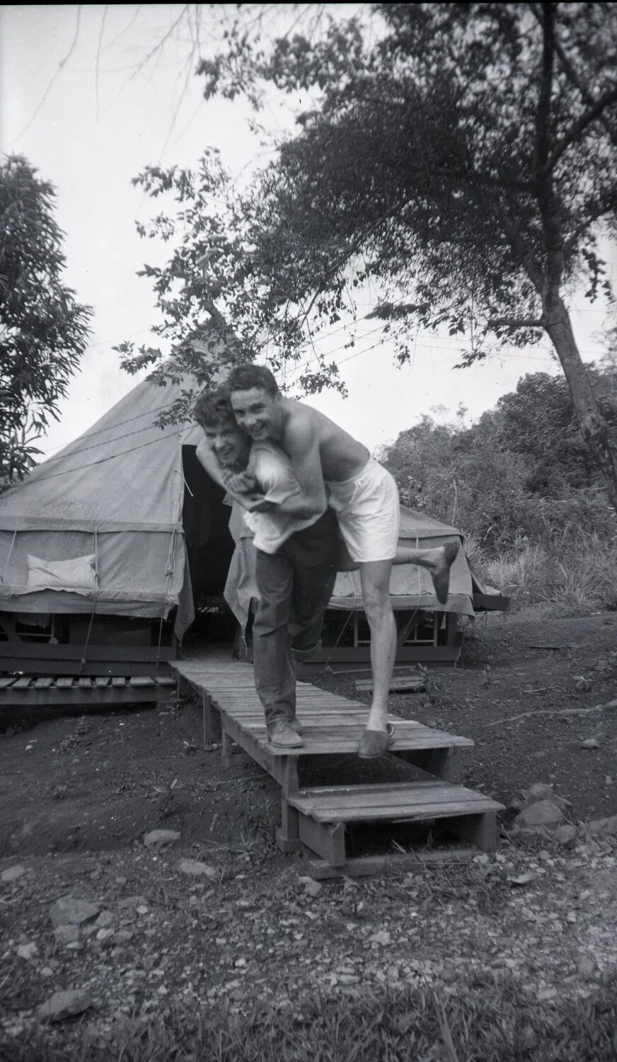 Servicemen Horsing Around on Boardwalk at Tropical Tent Camp