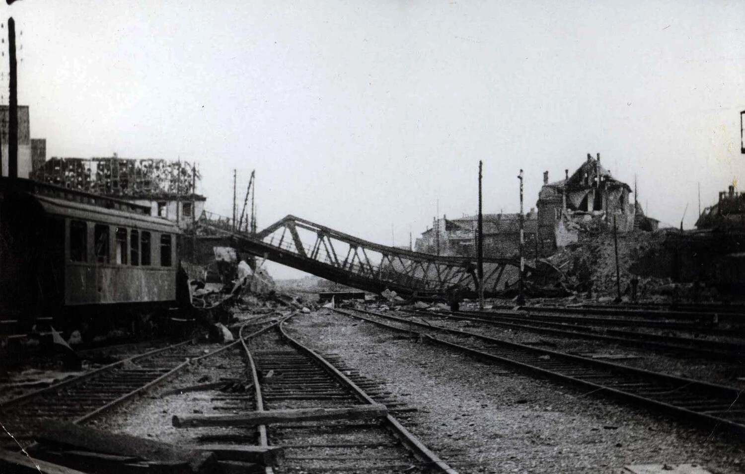 Bomb-Damaged Railway Yard with Collapsed Truss Bridge and Wrecked Rolling Stock, WWII European Theater