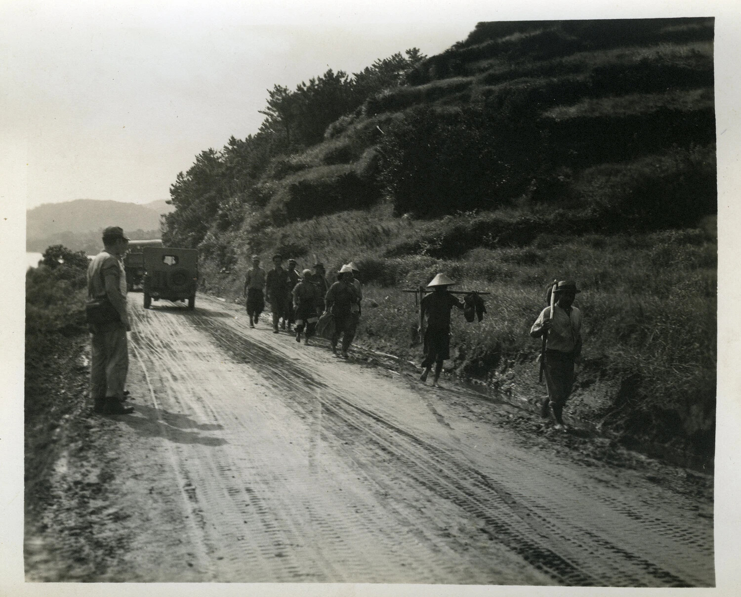 American Serviceman Observing Okinawan Civilians on a Coastal Road, Okinawa, WWII