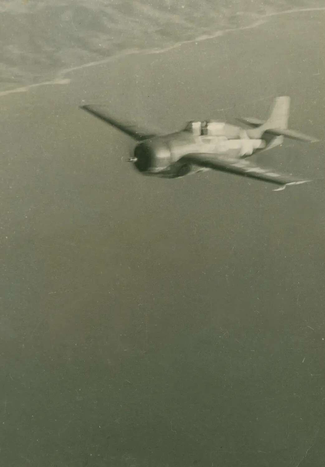 U.S. Navy Torpedo Bomber in Flight Over Coastline, WWII Era