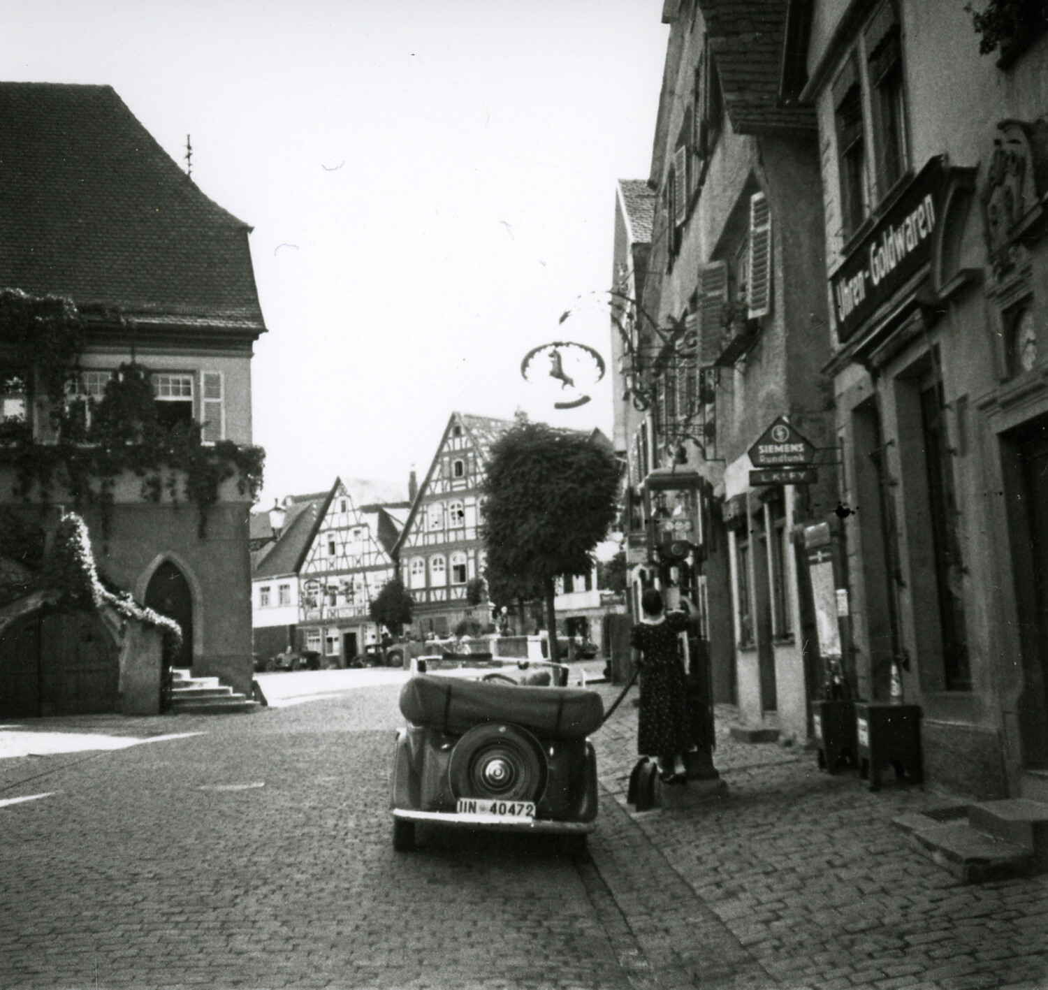 Cobblestone Town Square with Half-Timbered Buildings and Vintage Automobile, Postwar Germany