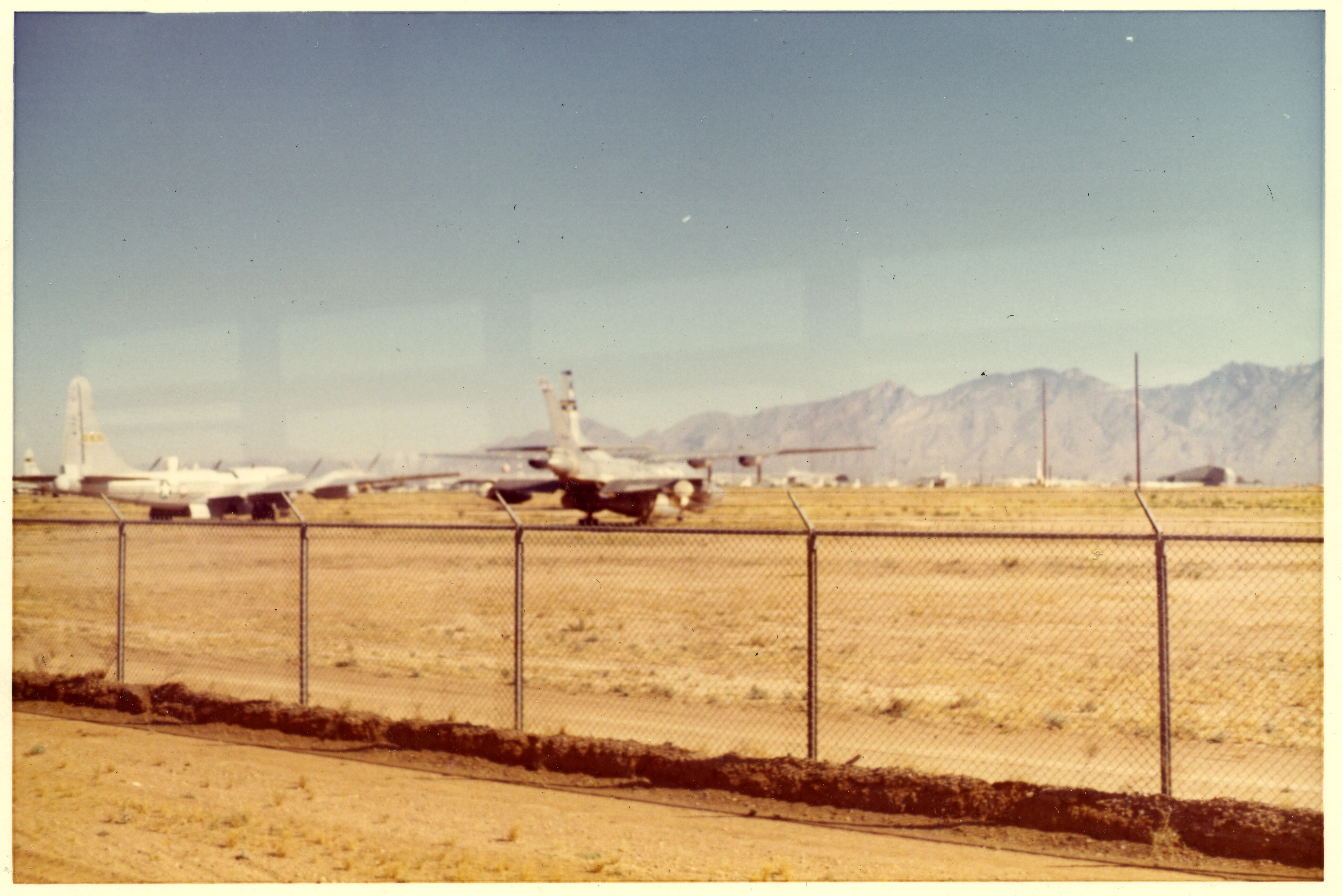 Aircraft in Storage Behind Security Fence, Desert Airfield (Likely Davis-Monthan AFB Boneyard)