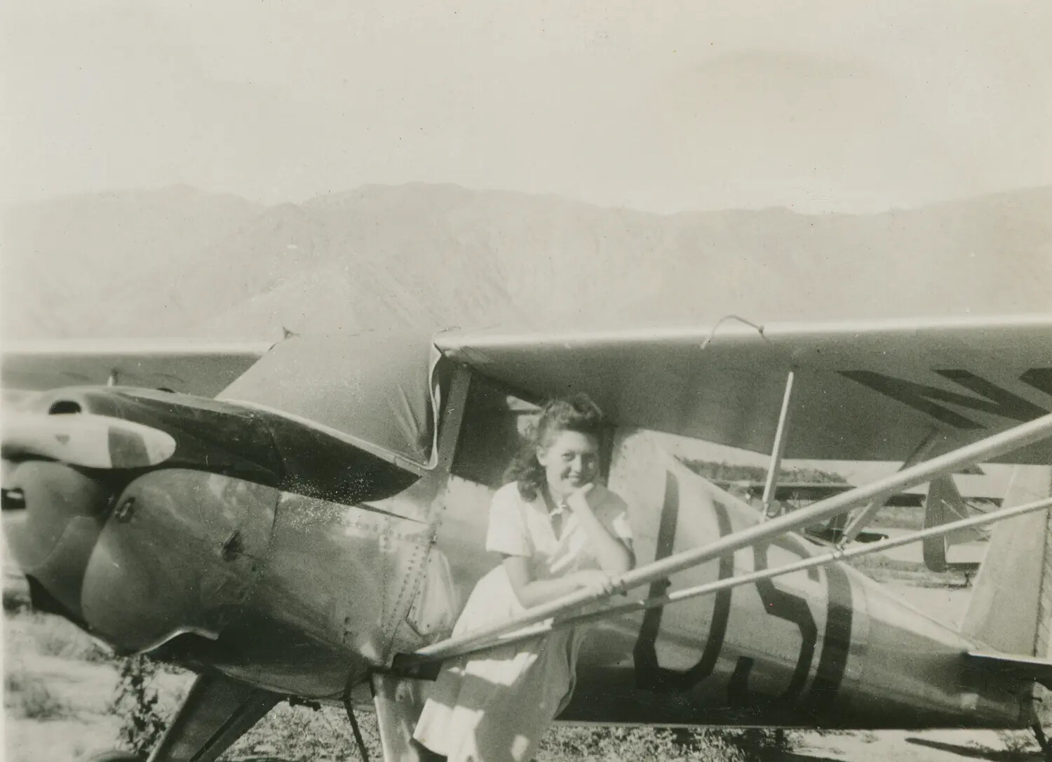 Woman Posing in Cockpit of Light Civilian Aircraft, Desert Airstrip, McAleer Family Collection