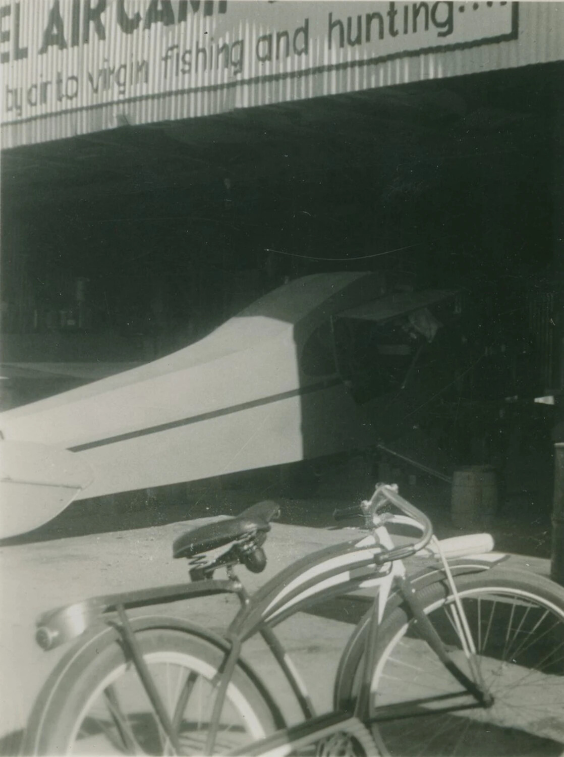 Snapshot: Fly-In Fishing and Hunting Camp Hangar Signage with Light Aircraft -- '...el Air Camp'