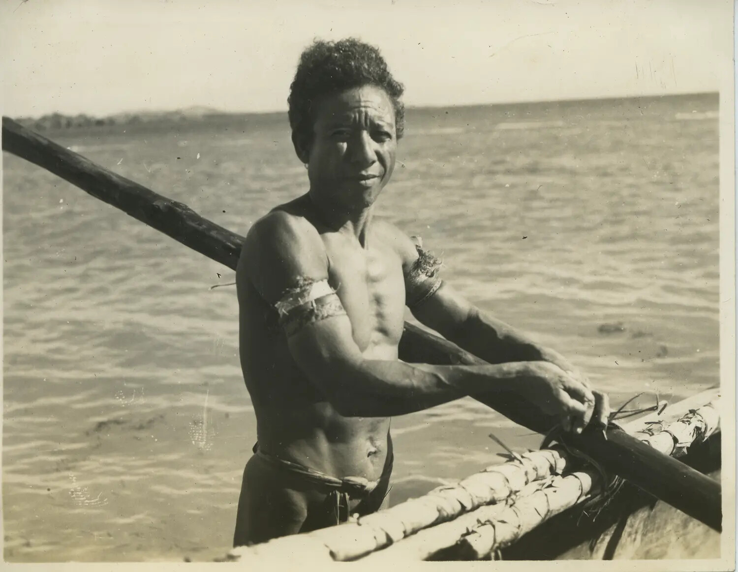 Portrait of a Pacific Islander Man Beside an Outrigger Canoe