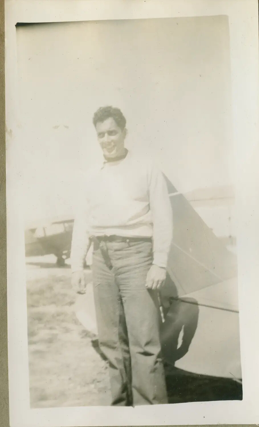 Young Man Beside Biplane Trainer Tail Section on Airfield