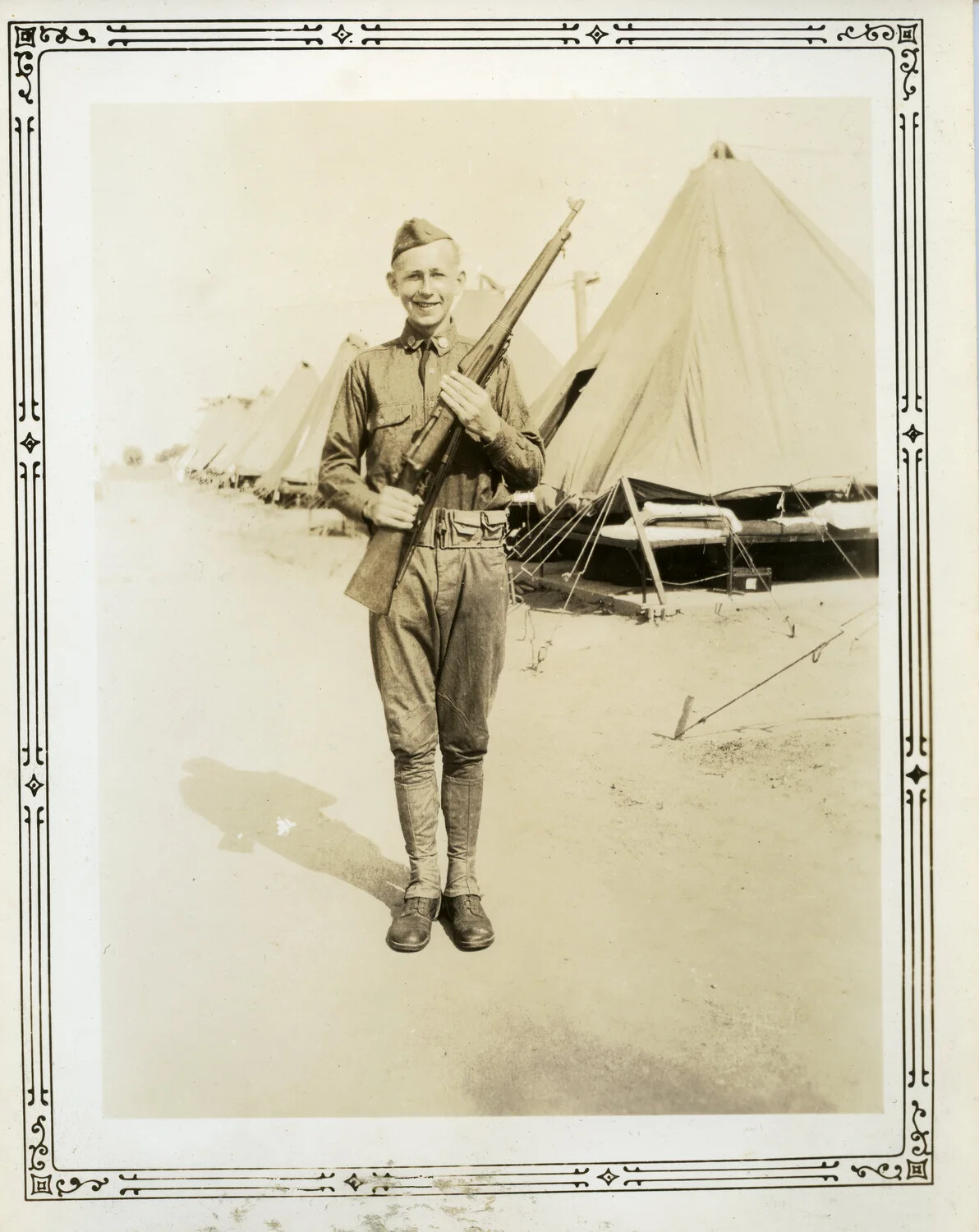 Portrait of U.S. Army Soldier with Rifle at Tent Camp, WWII Era