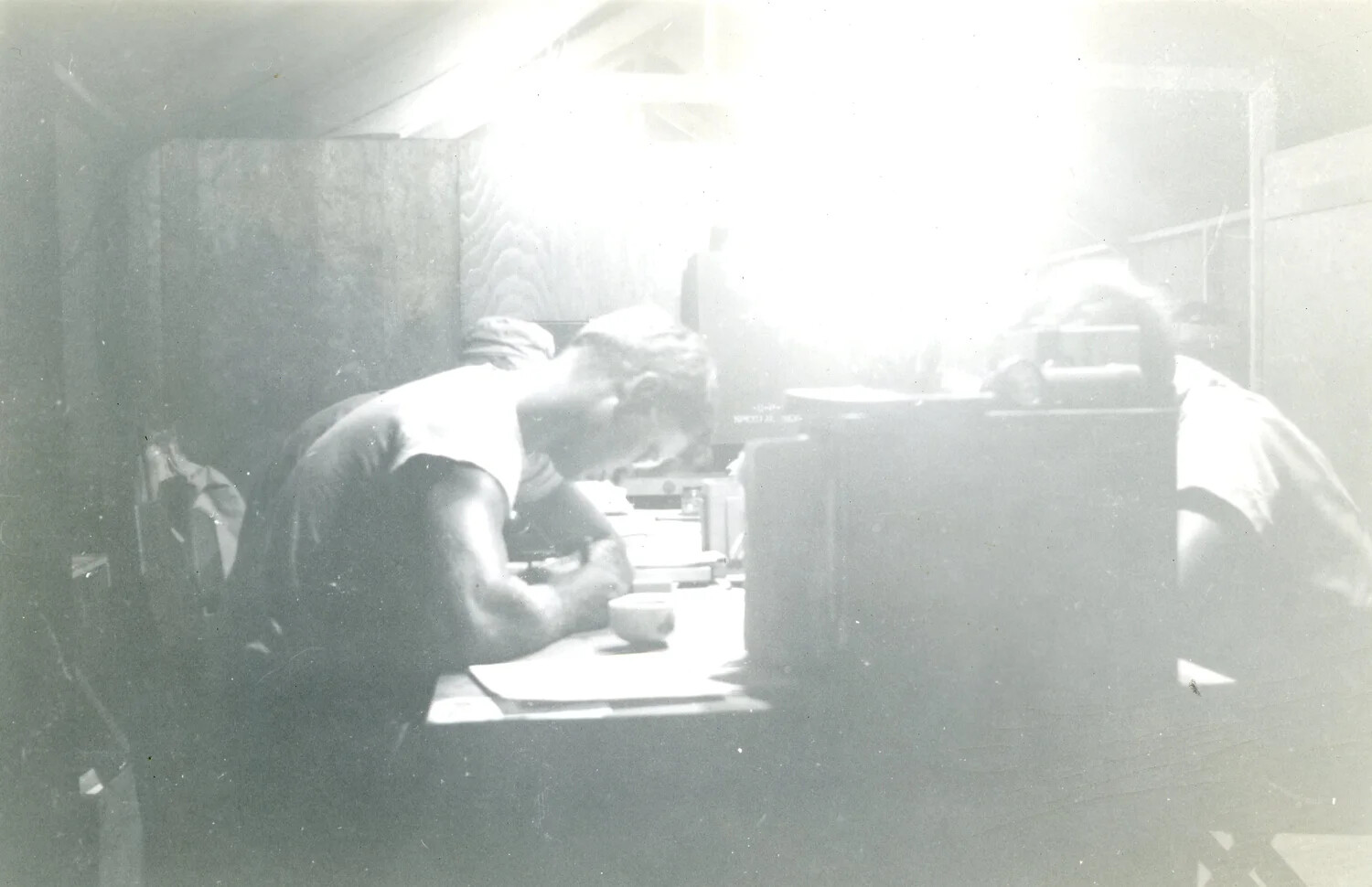 Serviceman at Table Inside Tent, Overexposed Interior View, Pacific Theater, WWII