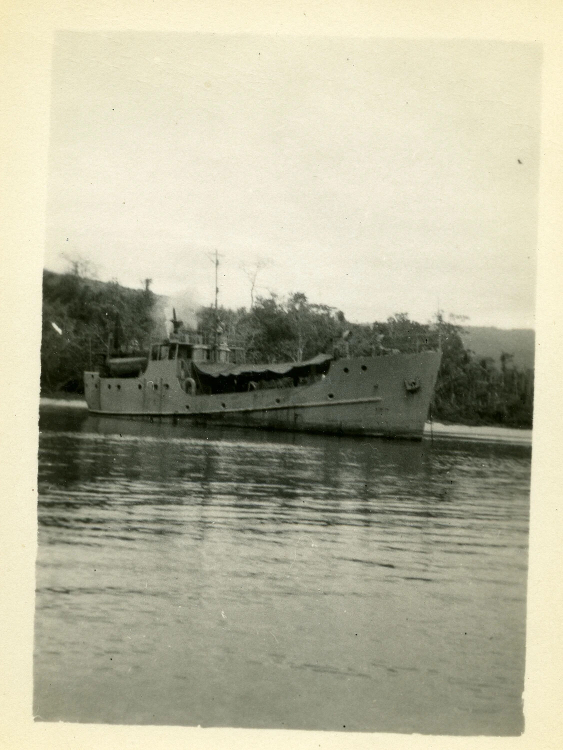 U.S. Army Coastal Transport Vessel at Anchor off a Jungle-Lined Shore, Southwest Pacific Area, World War II
