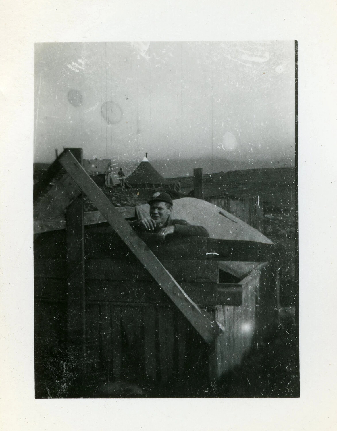 Serviceman at Wooden Shelter Under Construction, Remote Outpost, World War II Era