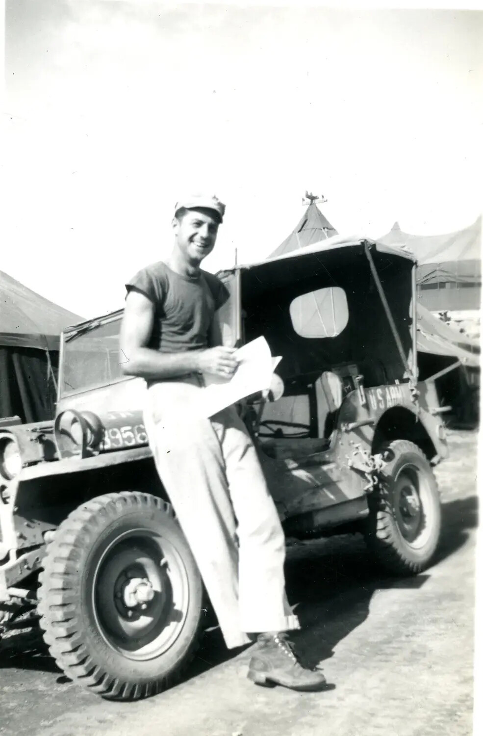 Serviceman Reading Letter Beside U.S. Army Jeep, Pacific Theater, WWII