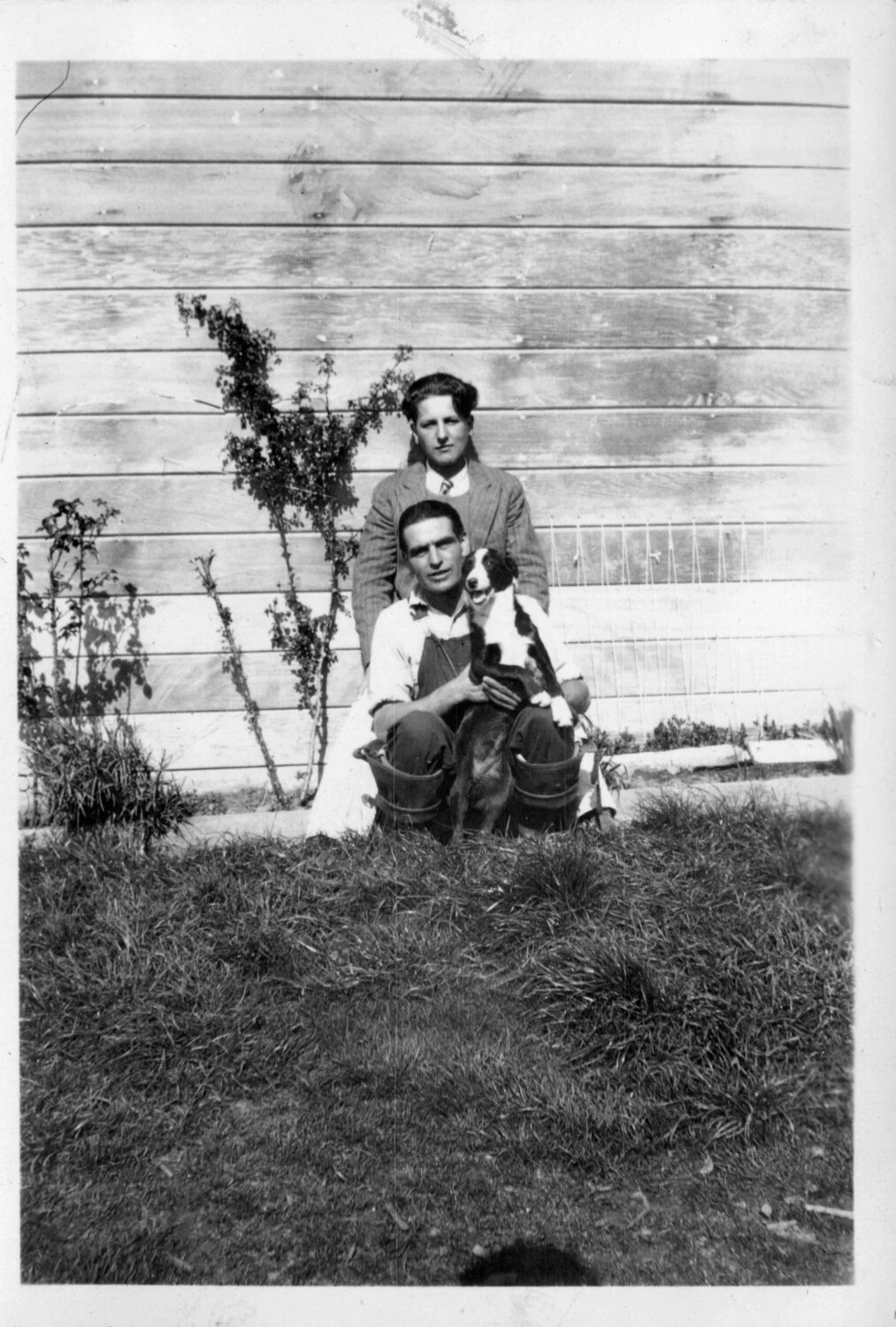 Two Men with a Dog Beside a Farmhouse Wall, circa 1920-1928