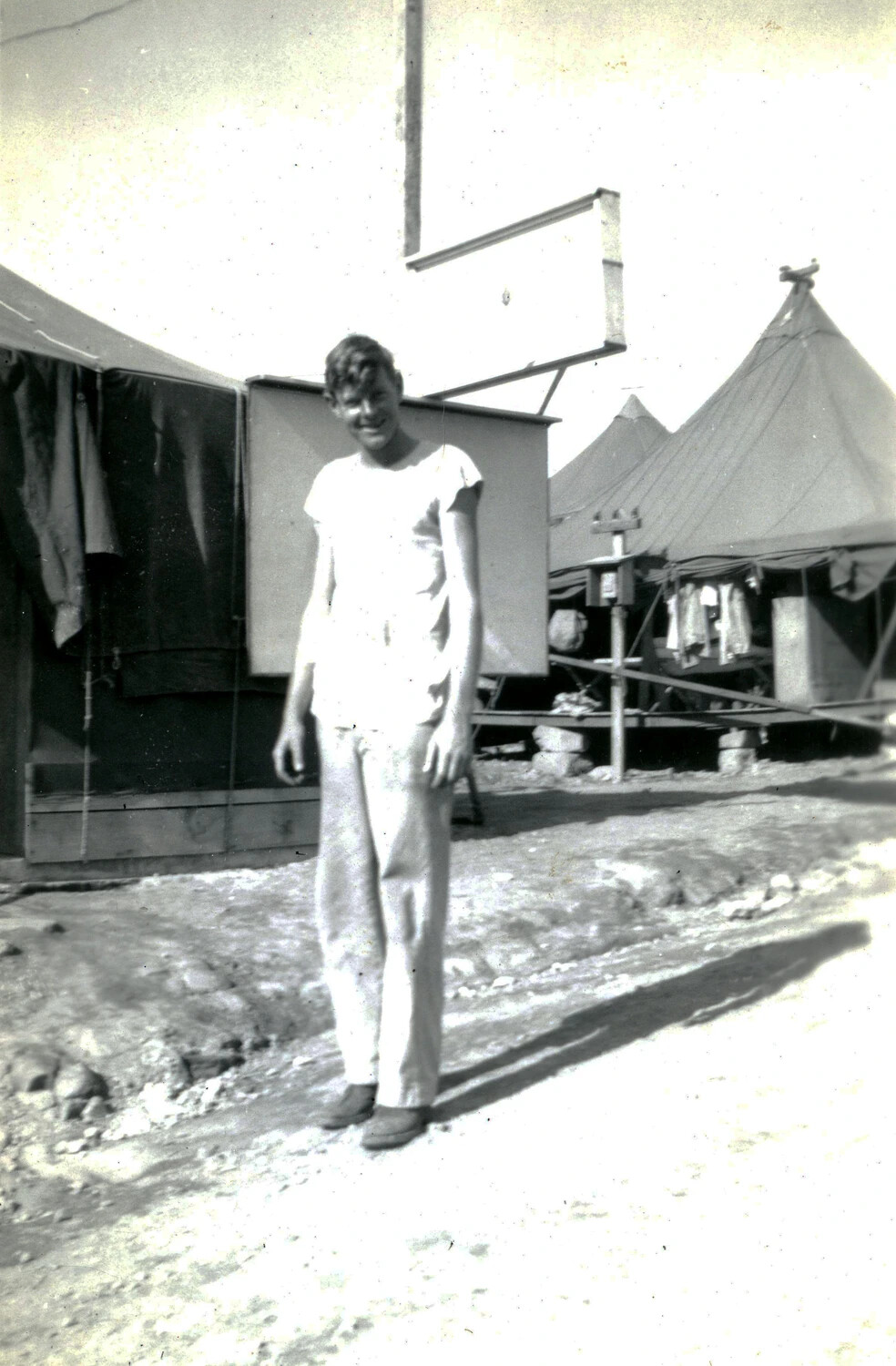 Portrait of a U.S. Marine in Camp Street with Tents and Signboard, WWII