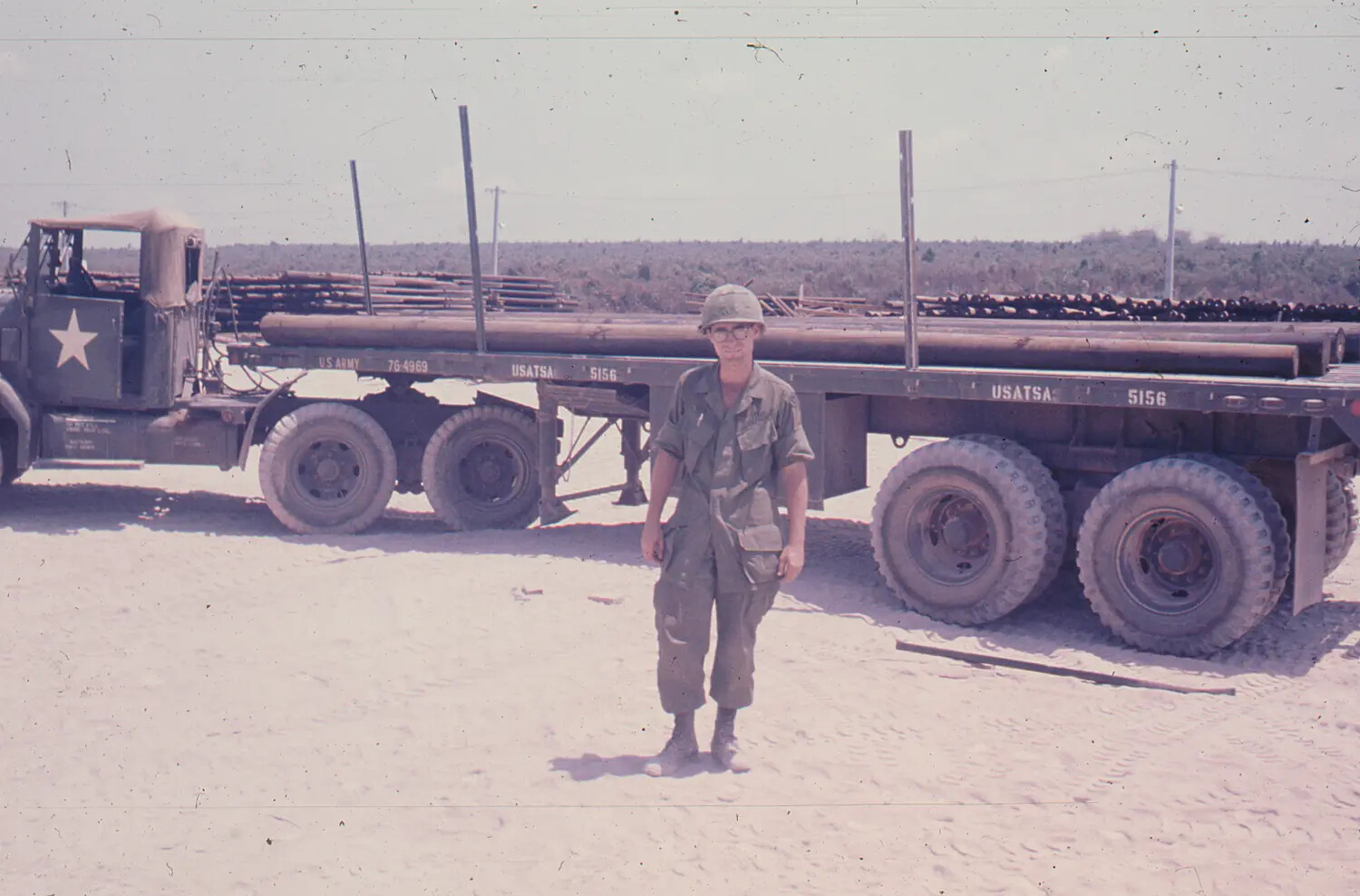 U.S. Army Soldier with USATSA Flatbed Trailer Loaded with Pipe, Vietnam, 1968