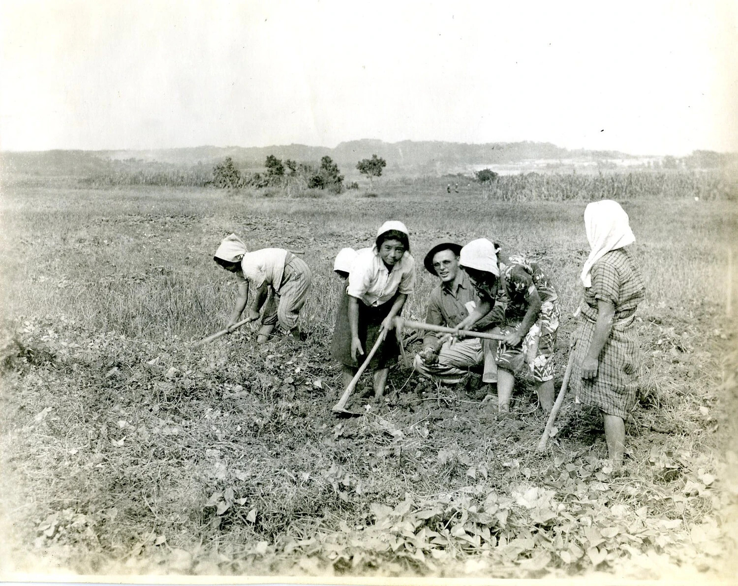 American Serviceman with Local Okinawan Farmers in Field