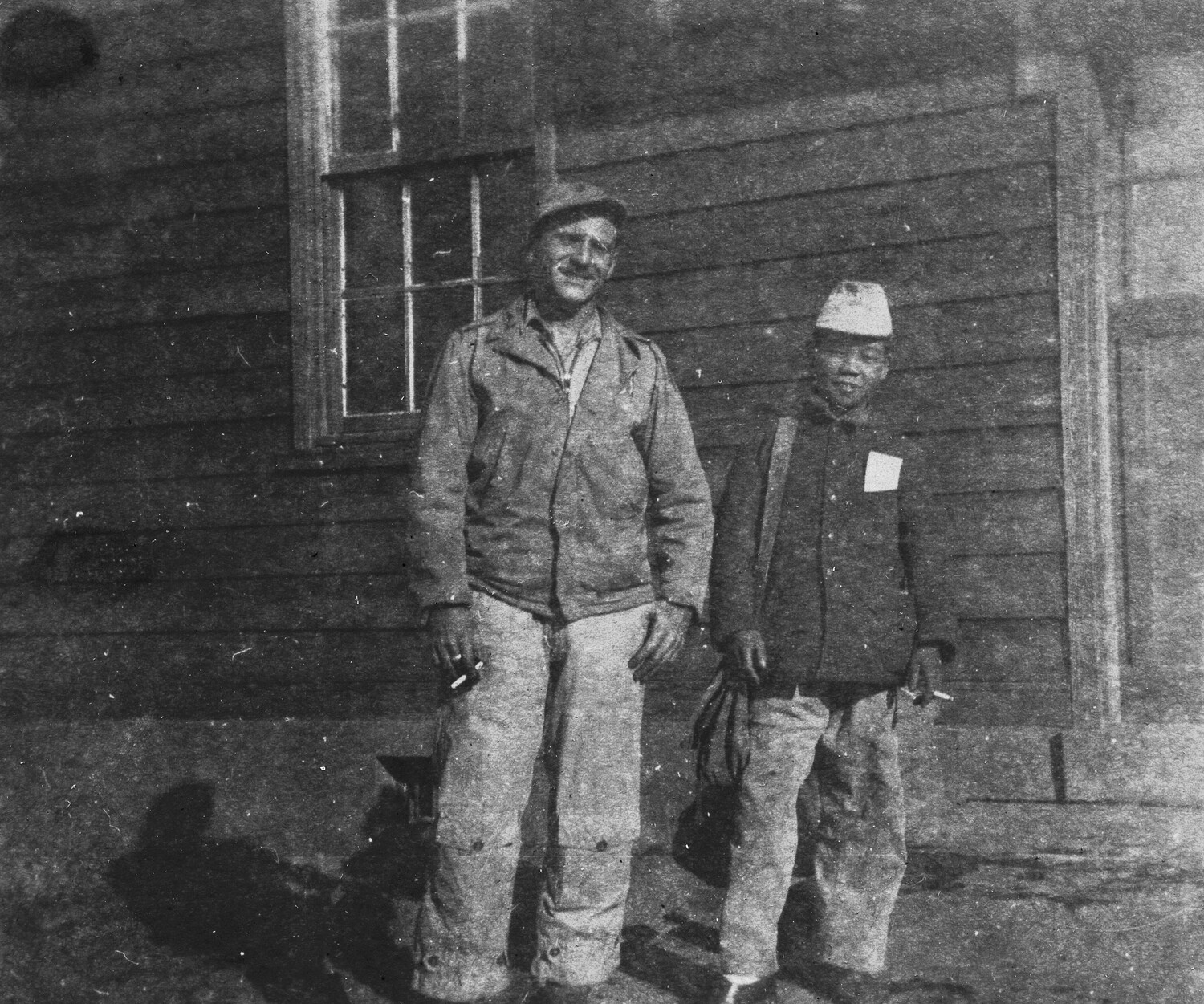 American Airman and Local Worker Outside Barracks Building, Ie Shima, 345th Bombardment Group, WWII