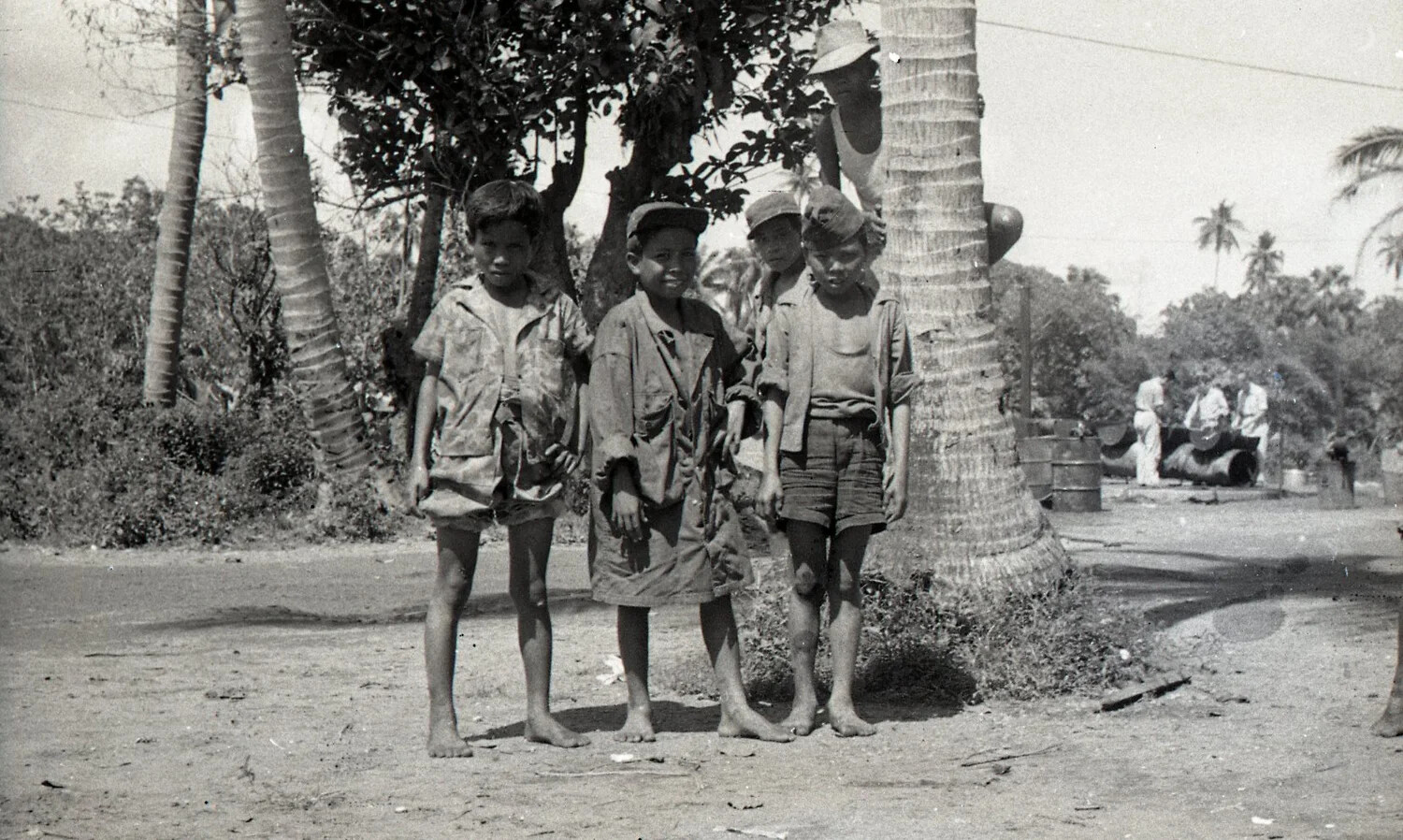 Filipino Boys Beside a Roadside Palm Tree Near a U.S. Camp, Luzon, Philippines, WWII Era