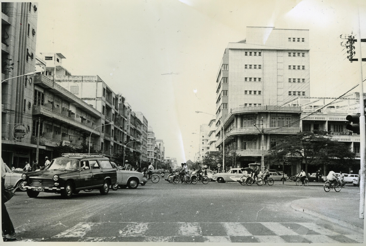 Busy Downtown Intersection with Shell Sign and Mixed Traffic, Phnom Penh, Cambodia, c. 1960s