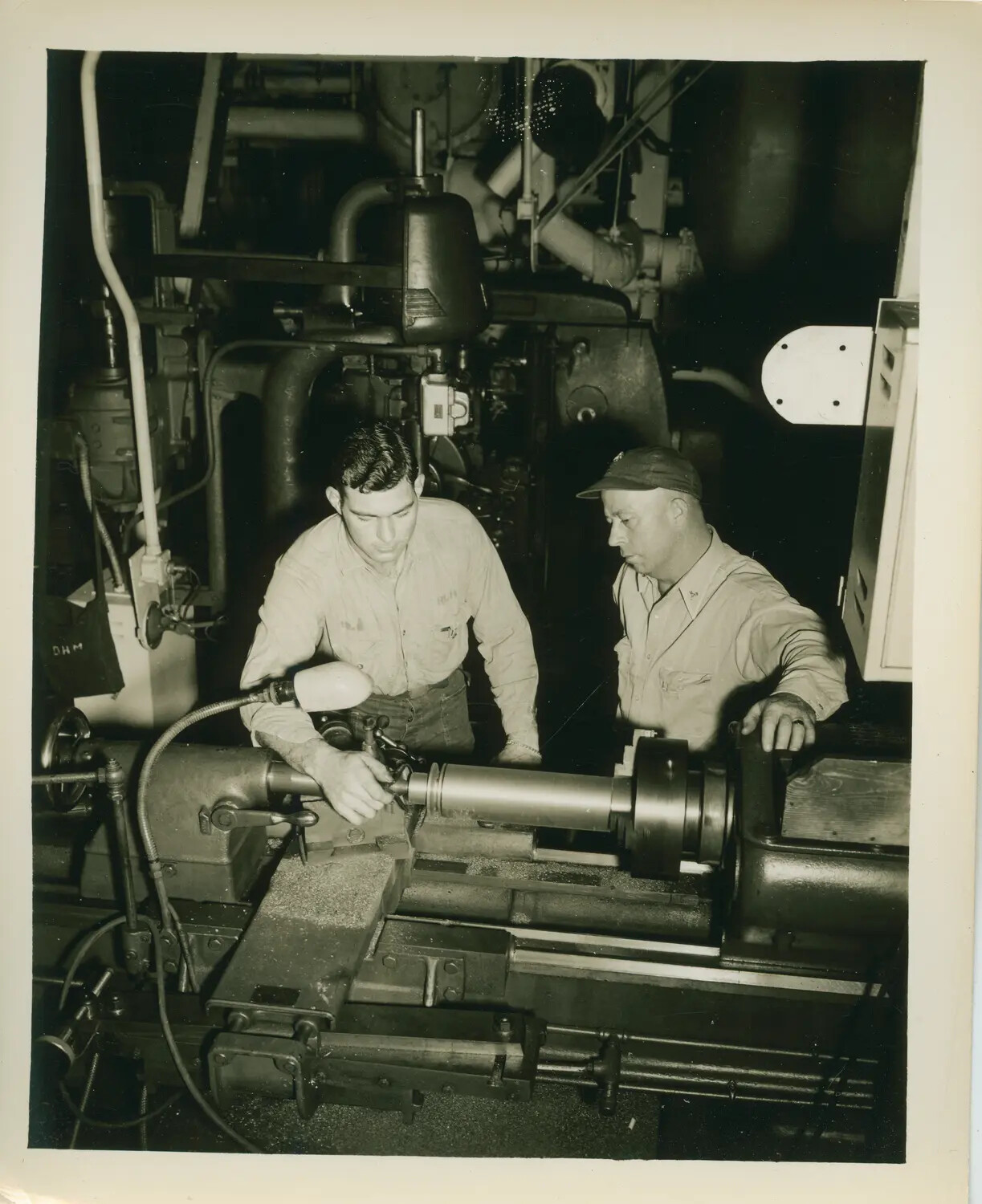 Shipboard Machine Shop: Sailors Operating a Metal Lathe Aboard USS Petrof Bay (CVE-80)