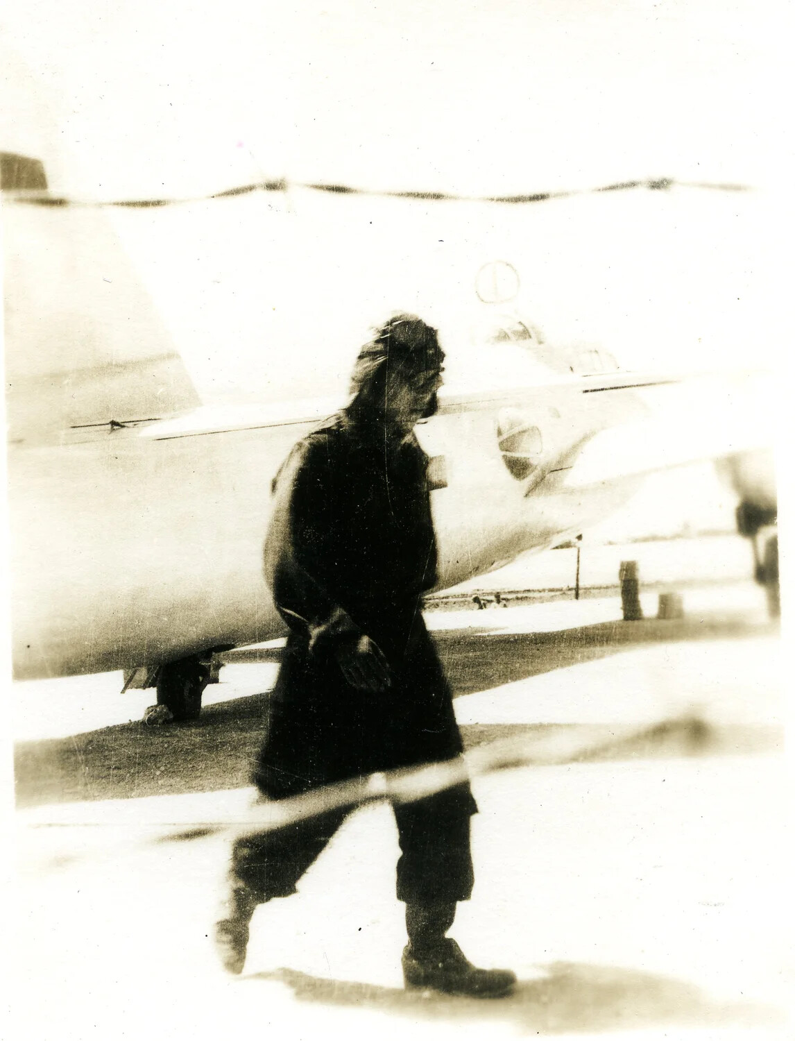 Airman Walking Past a Parked Aircraft on Ie Shima Airfield