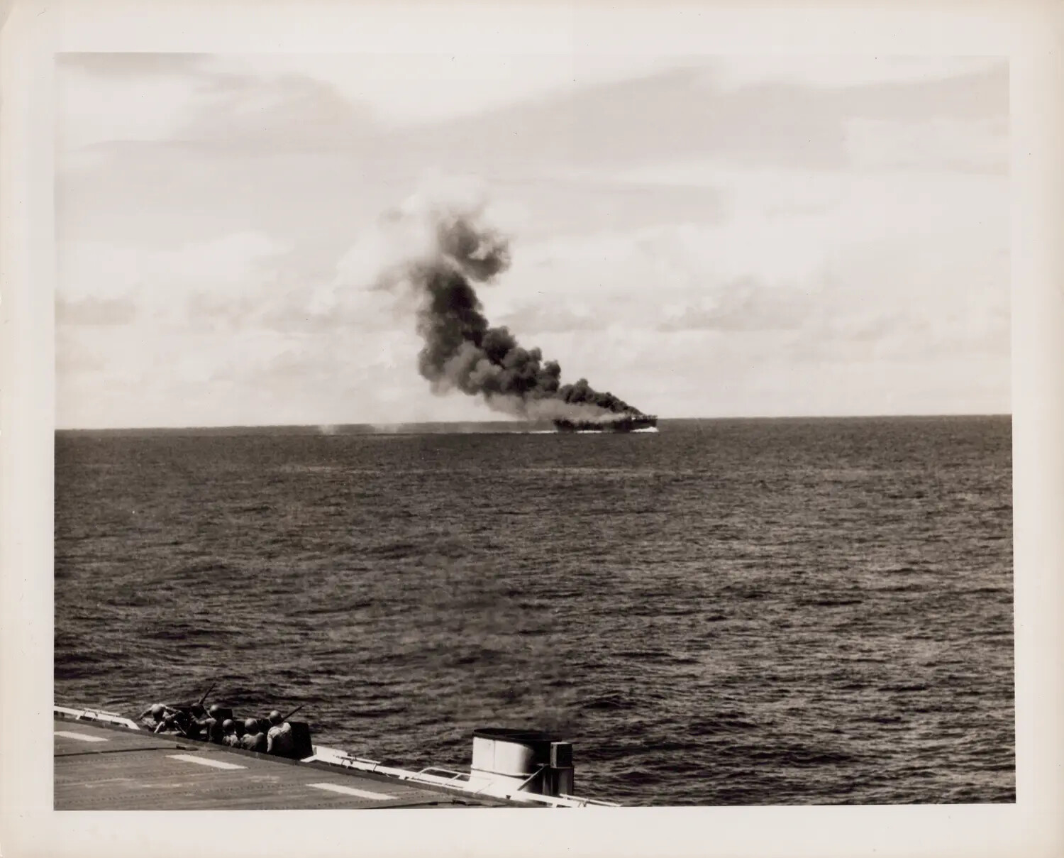 Distant Ship Fire and Smoke Column Viewed from a U.S. Navy Escort Carrier's Flight Deck and Gun Tub, WWII Pacific Theater, October 1944