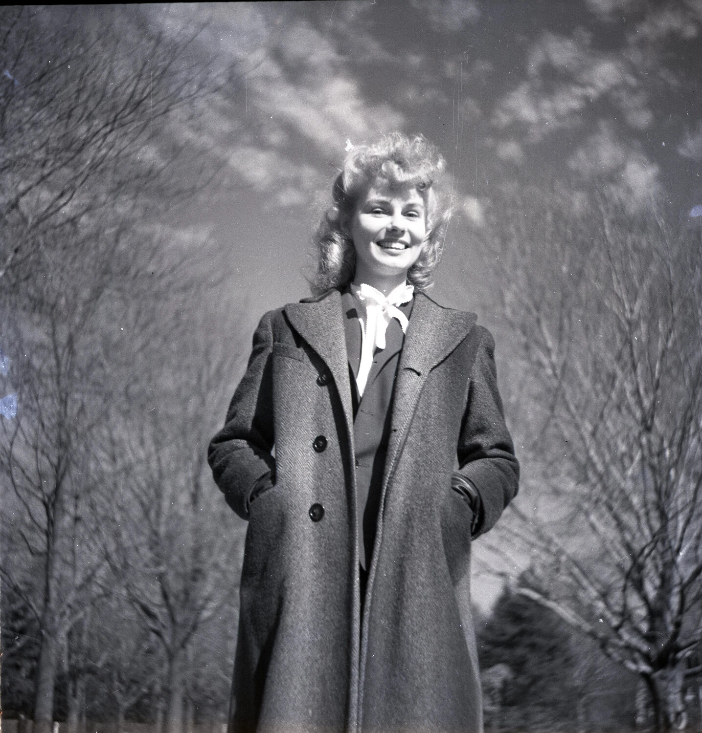 Low-Angle Portrait of a Young Woman Outdoors in Wool Coat
