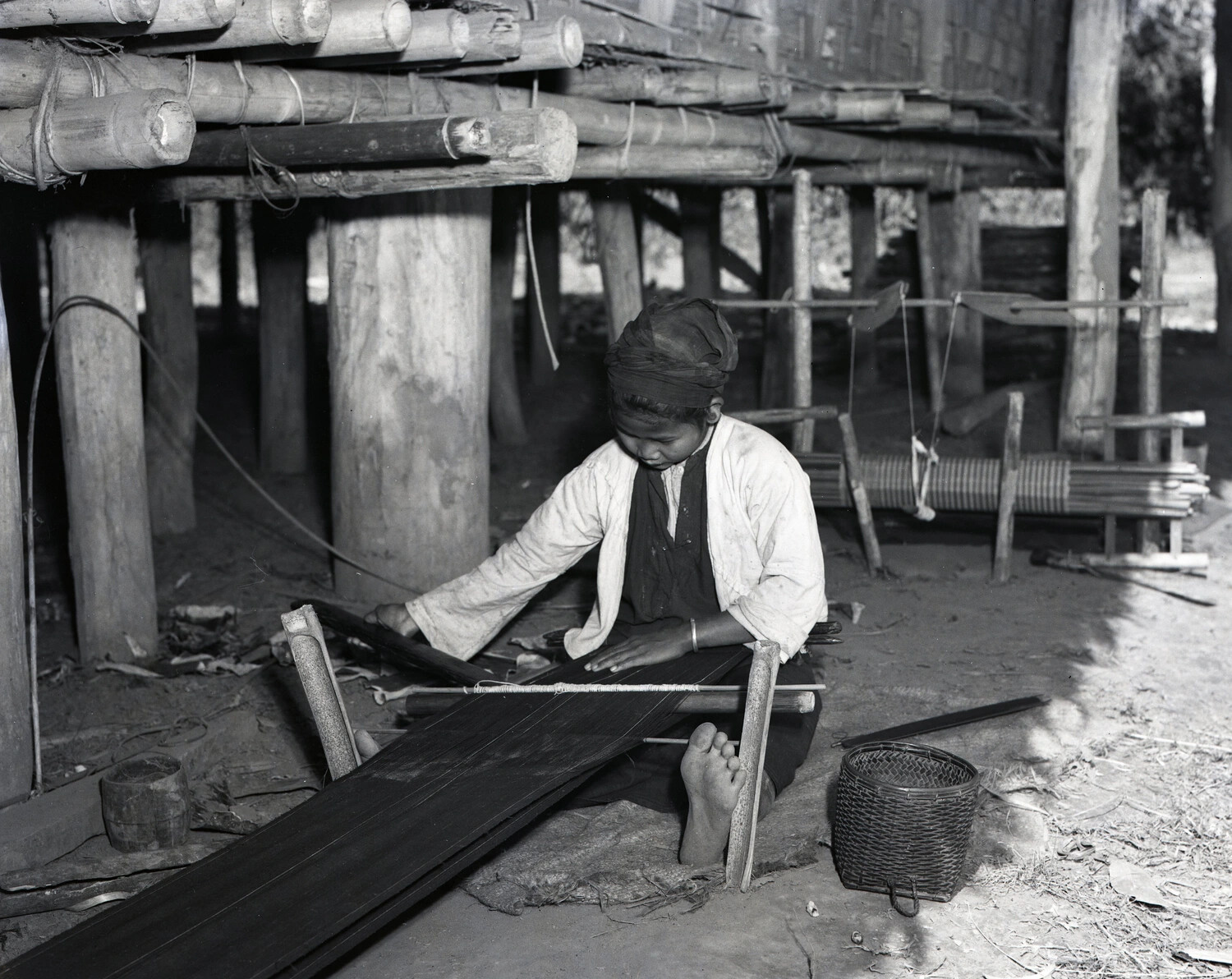 Burmese Woman Weaving Cloth on Backstrap Loom Beneath Stilt House, WWII Burma