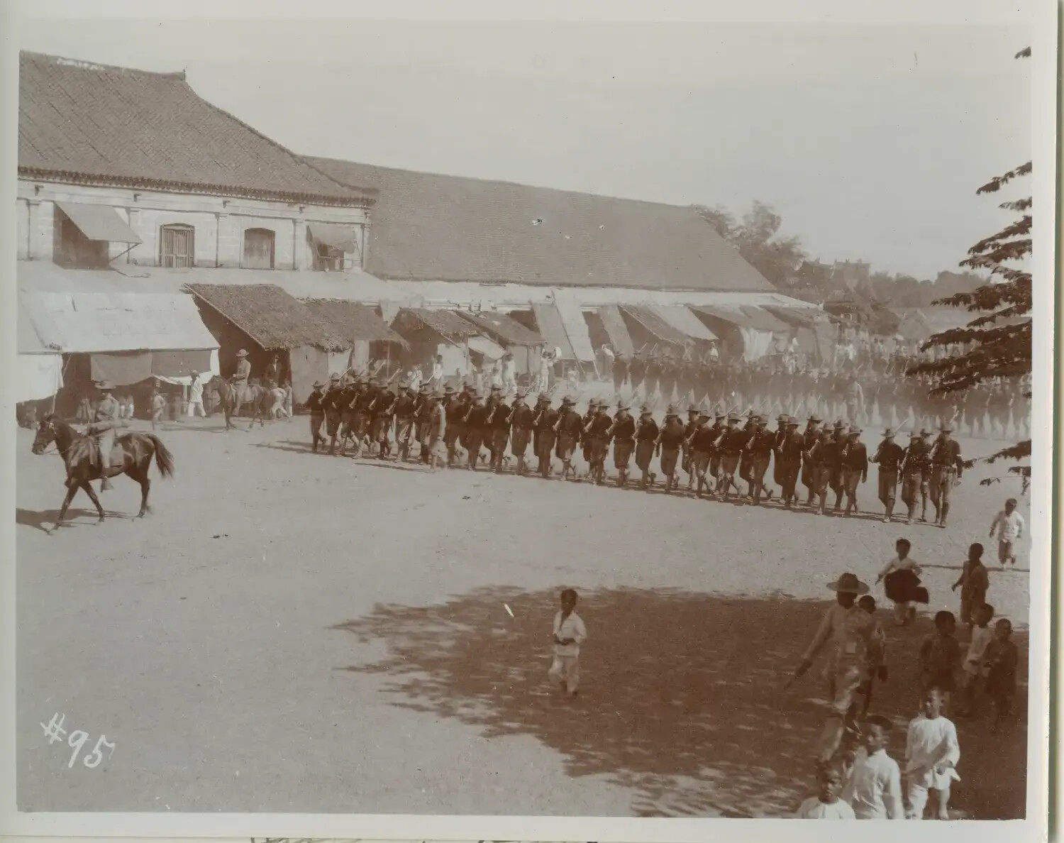 American Infantry Column Marching Through a Philippine Town Plaza, c. 1898-1900