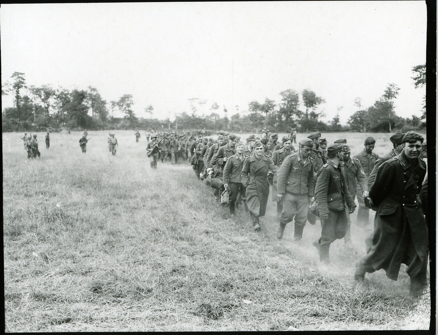 Column of German Prisoners of War Marching Under Guard Through the Normandy Countryside, Summer 1944