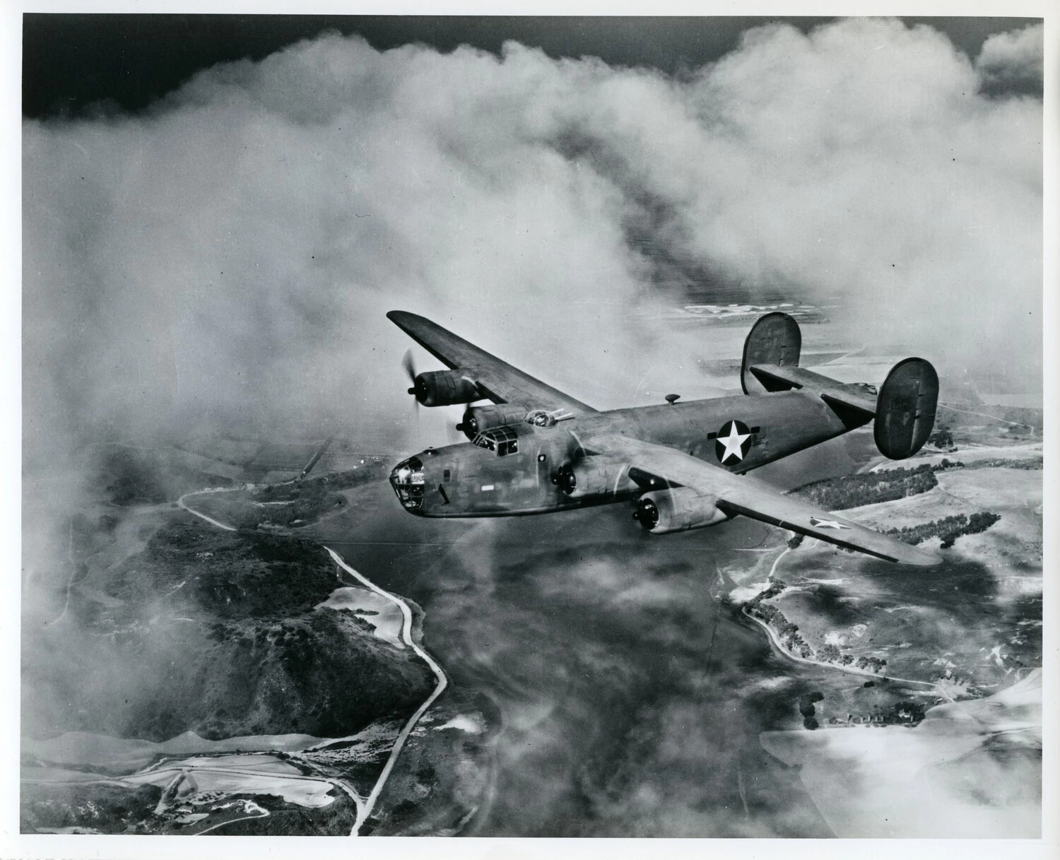 Consolidated B-24 Liberator Bomber in Flight Over Coastal Terrain