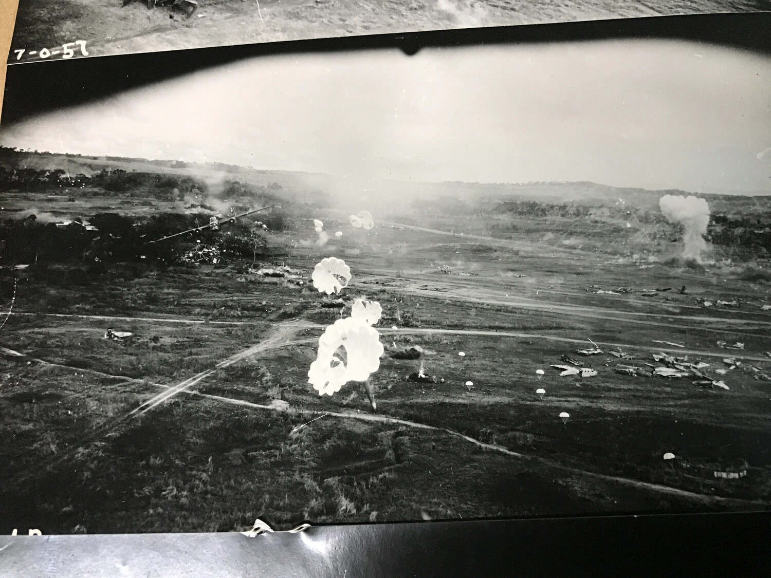 Parafrag Bombs Descending Over Japanese Airfield with Dispersed Wrecked Aircraft