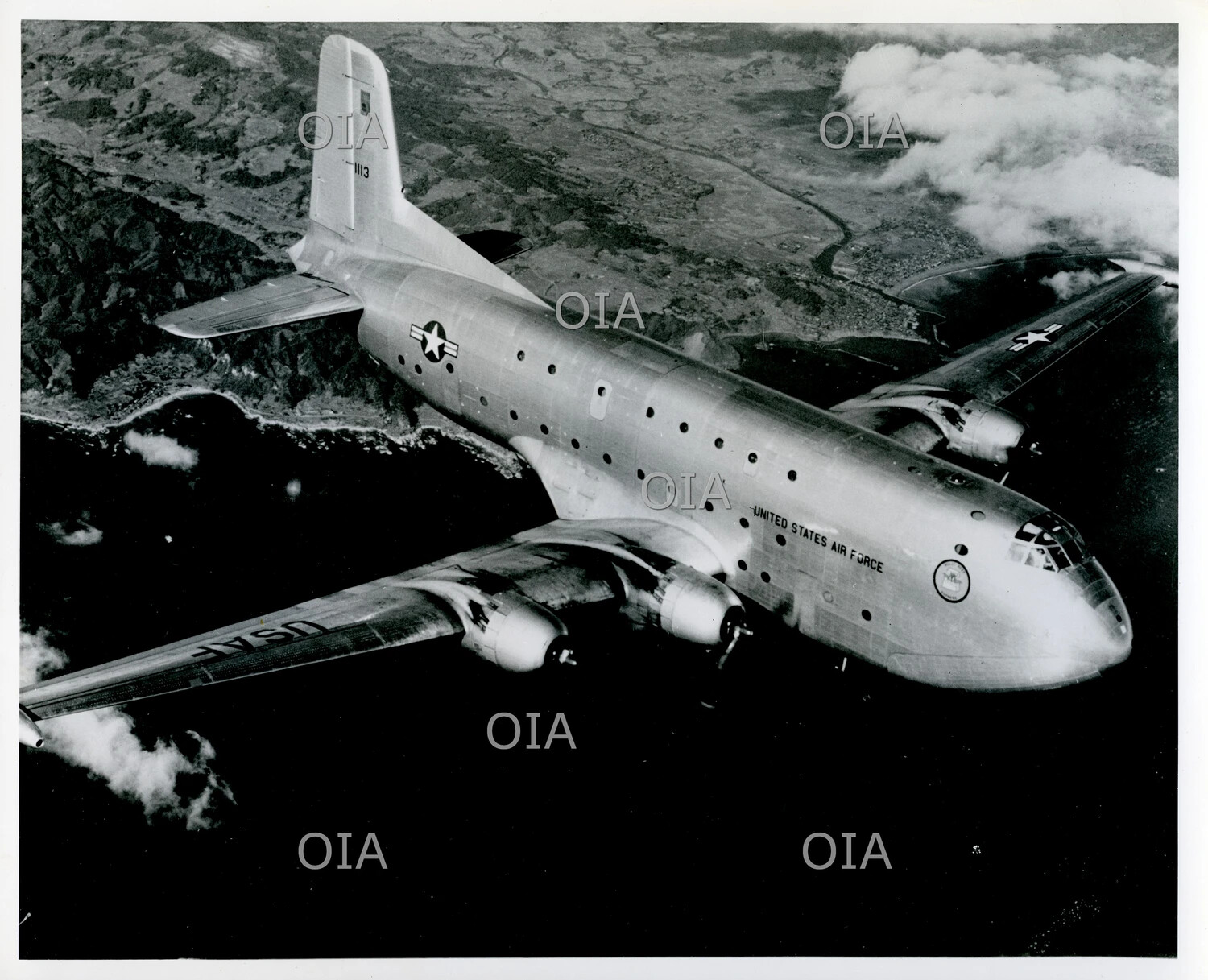 USAF Four-Engine Heavy Transport Aircraft (likely Douglas C-124 Globemaster II) in Formation Flight over Coastal Terrain