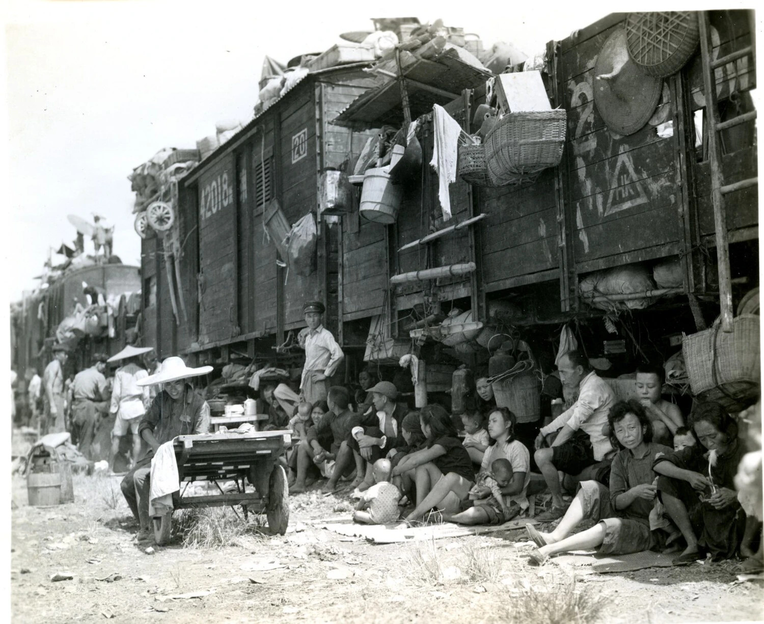 Refugee Families Sheltering Beside Boxcar No. 42018 During Wartime Rail Evacuation