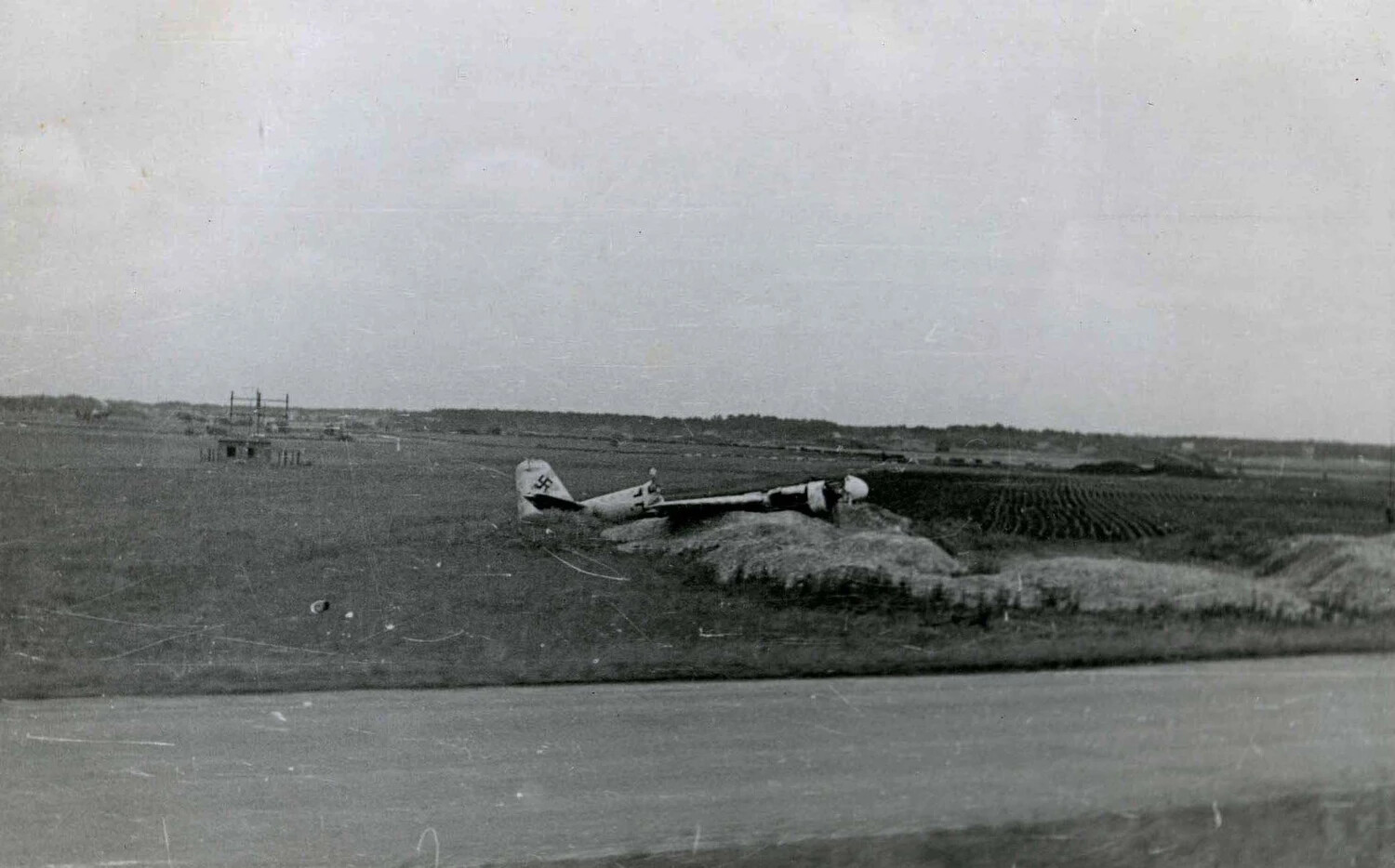 Abandoned German Aircraft with Swastika Tail Marking in Farmland, European Theater, WWII