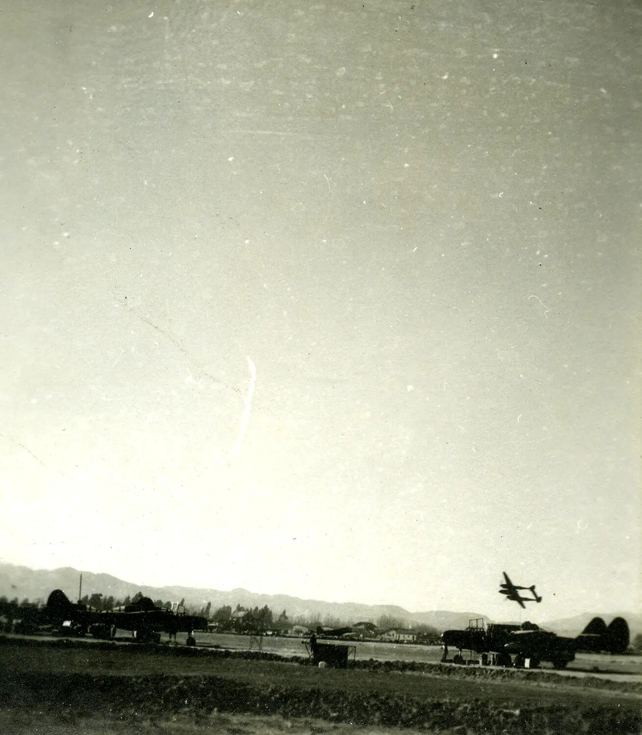 Twin-Engine Aircraft in Low Flight Over CBI Theater Airfield