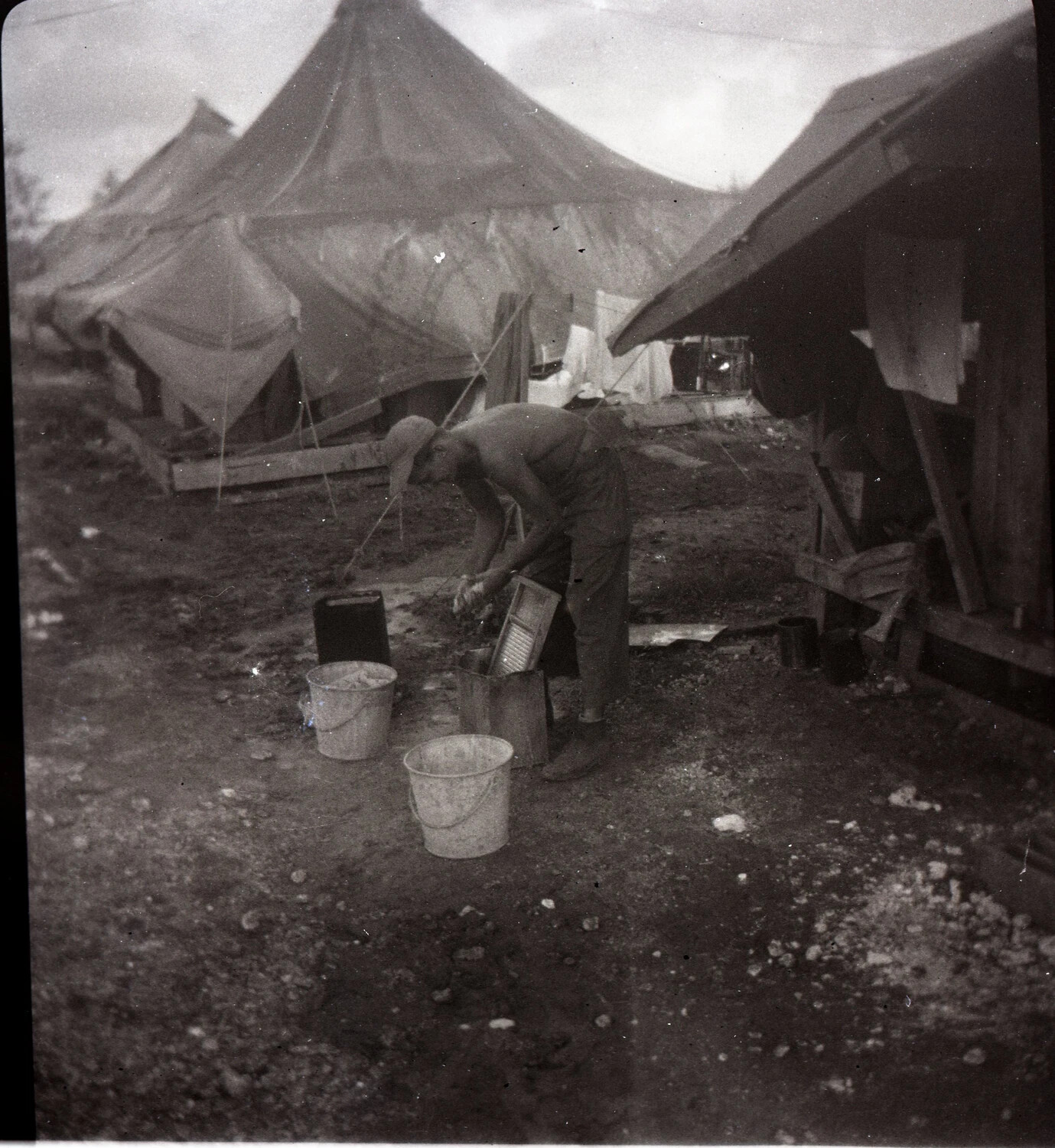 Serviceman Doing Laundry with Washboard in Camp Area — 345th Bombardment Group Encampment, Ie Shima, WWII