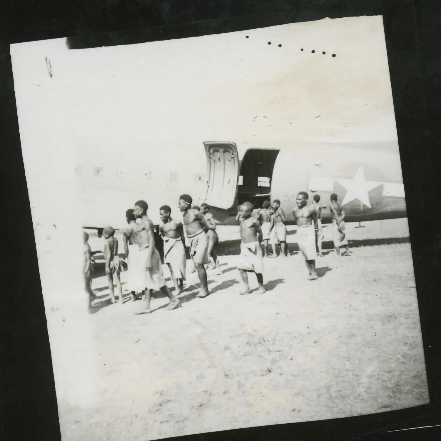 Local New Guinean Boys and Young Men Beside U.S. Transport Aircraft, World War II Era
