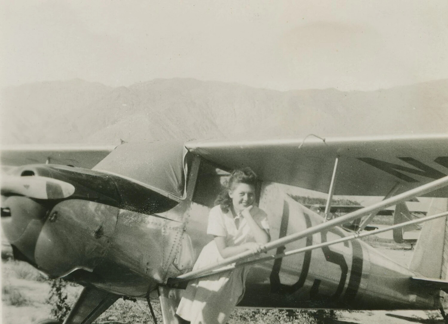 Woman Posing in Cockpit of Light Aircraft, Desert Airfield, McAleer Photo Album, WWII Era