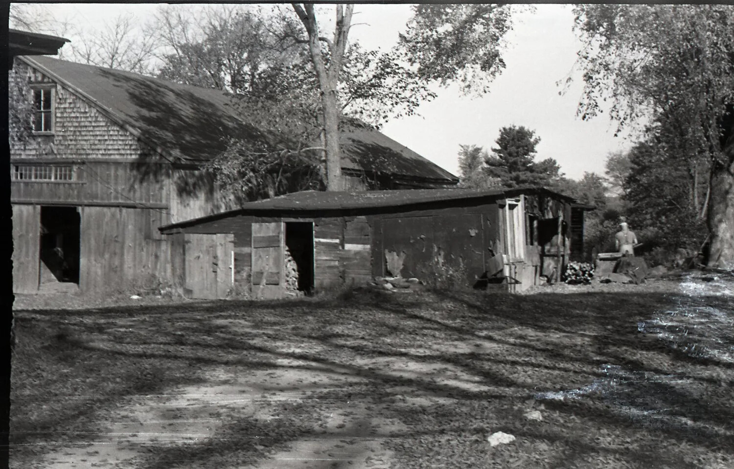 Farm Outbuildings with Woodshed and Distant Figure, Stateside, WWII Era