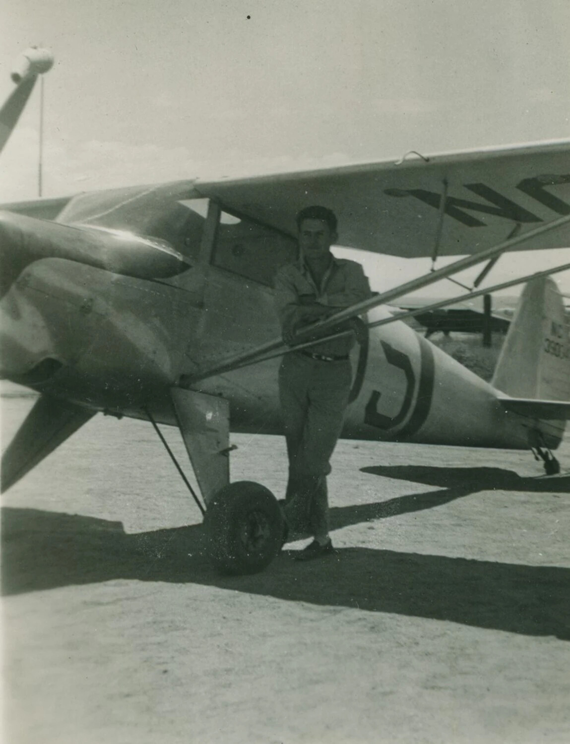 Man Posing with Light Civil Aircraft, Piper Cub-type Monoplane, McAleer Photo Album