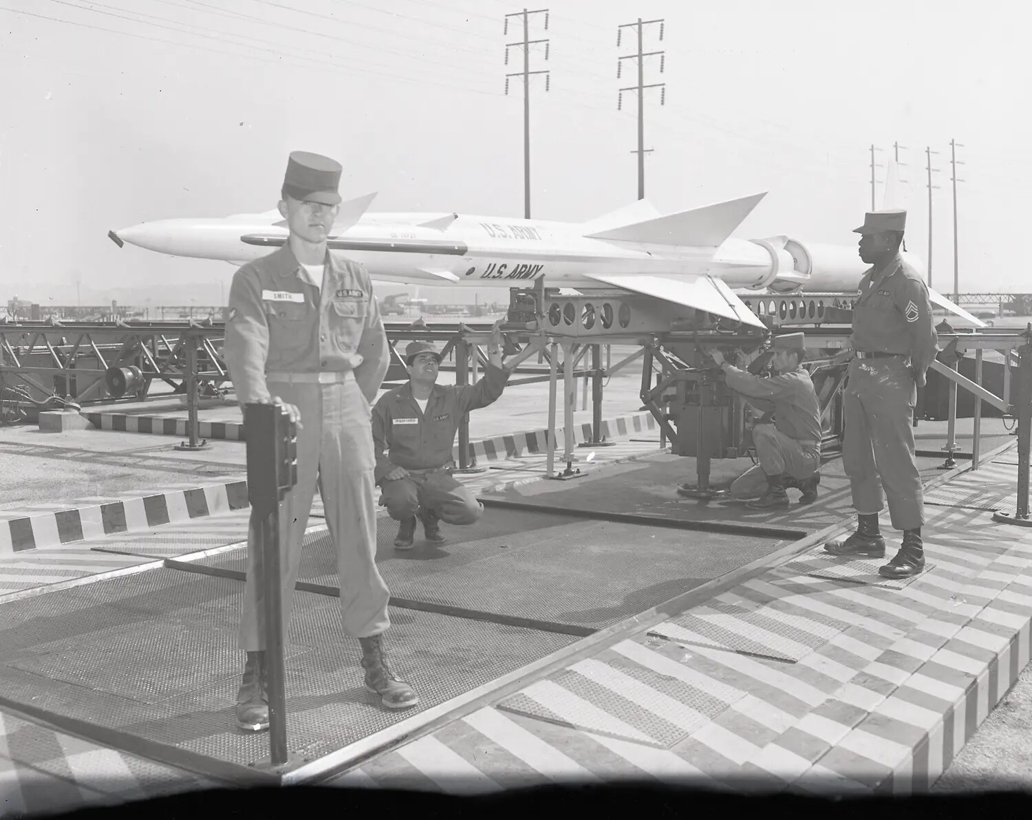 Soldiers with Nike Missile on Launcher Rail, Air Defense Site, Name Tape "SMITH" Visible