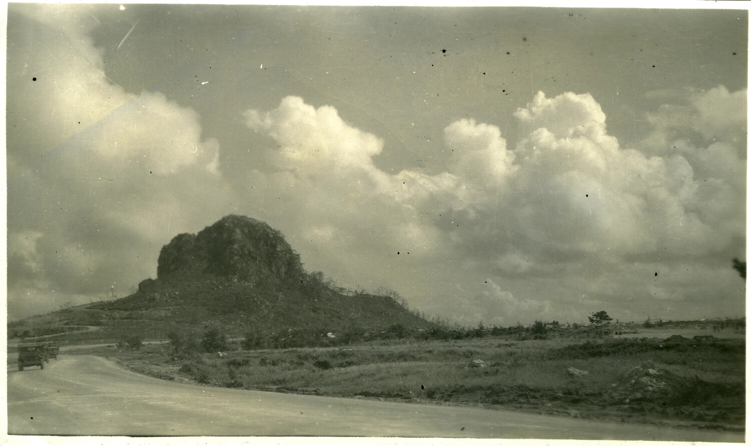 Military Convoy Passing a War-Scarred Rock Outcropping, Okinawa