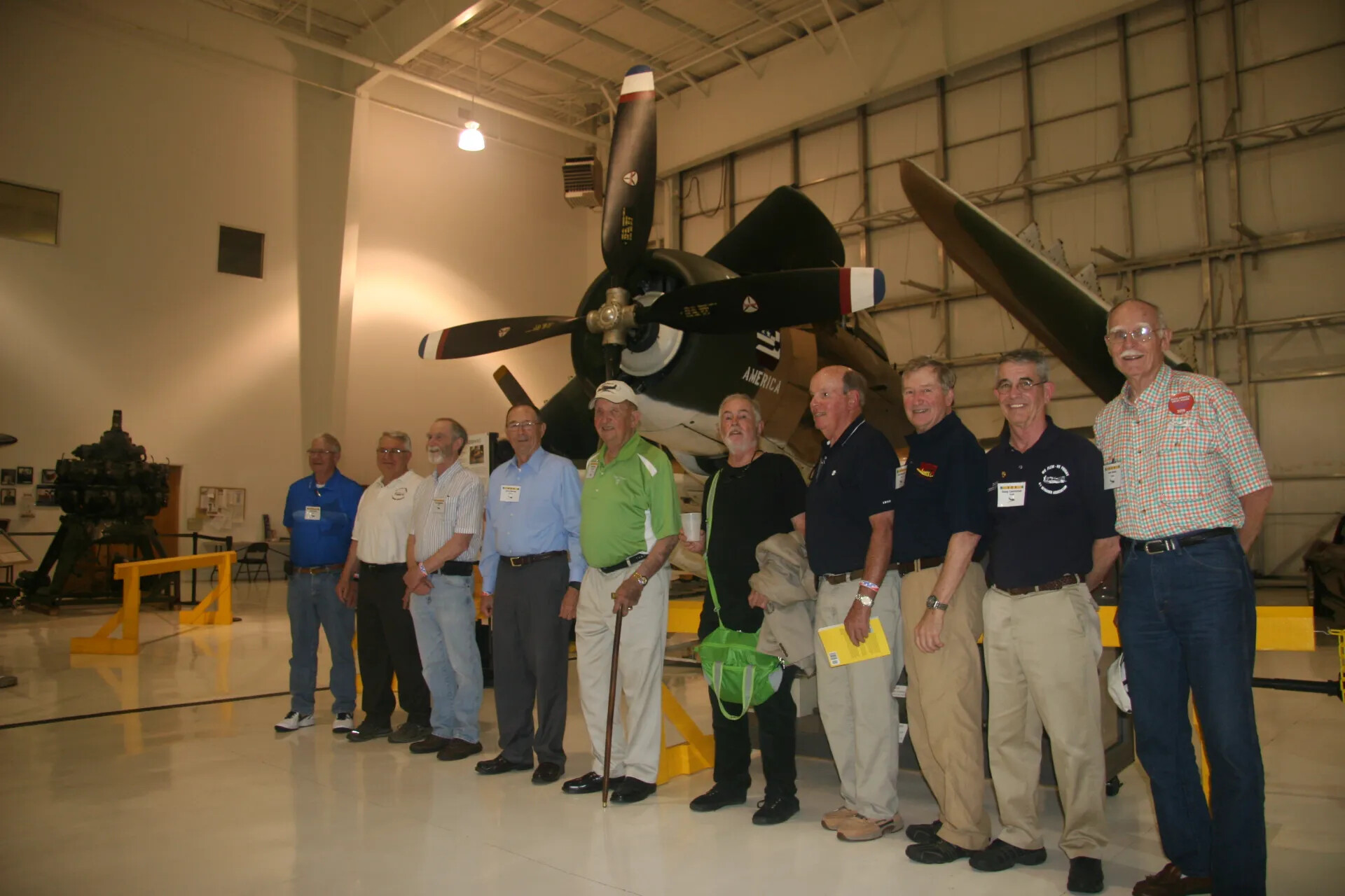 Veterans Reunion Group Portrait Beneath Restored A-1 Skyraider, Aviation Museum Hangar