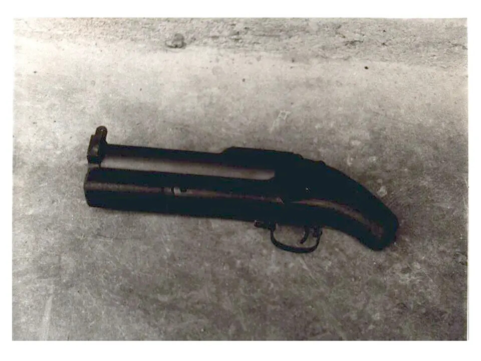 Close-Up of Small Double-Barreled Firearm on Concrete Surface